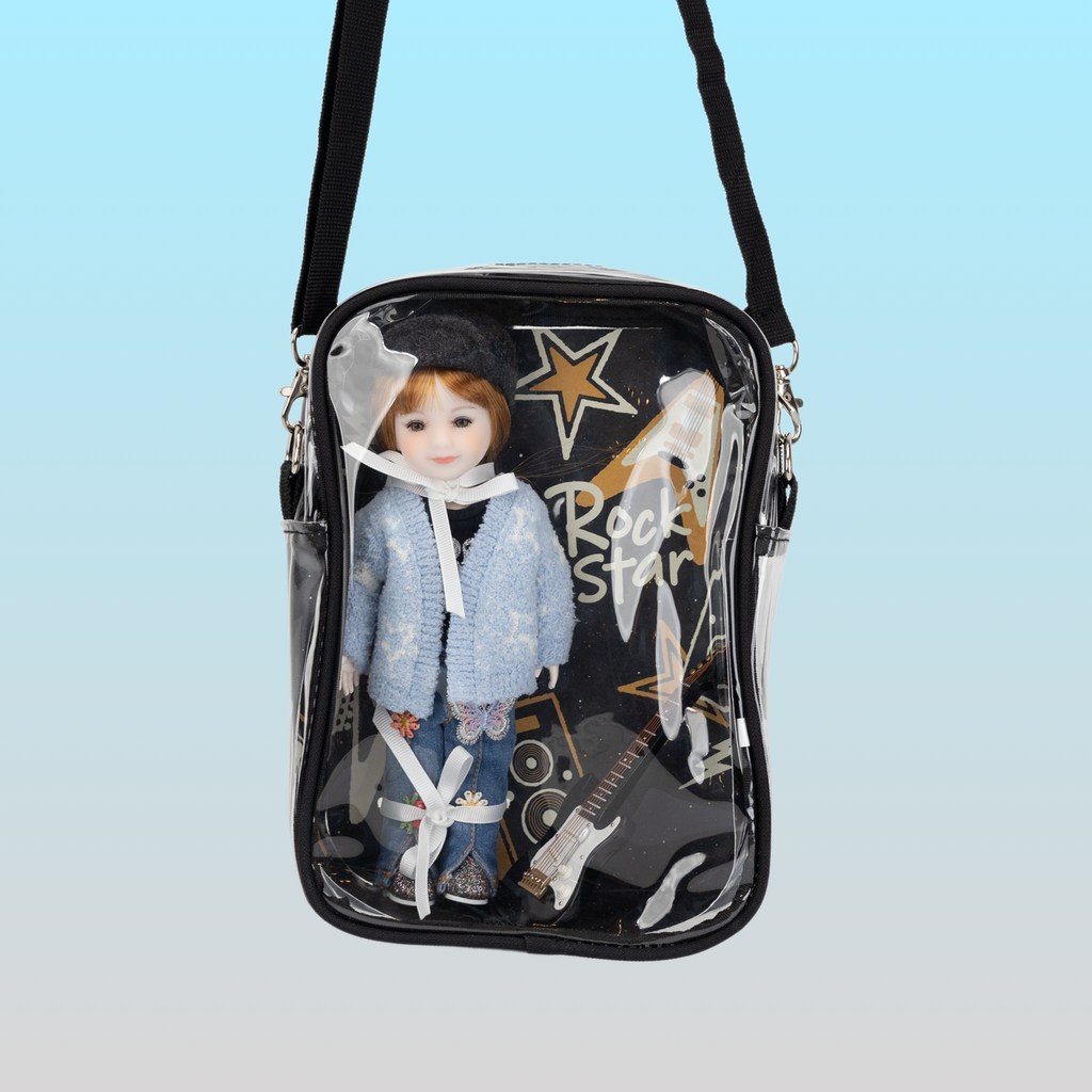Small crossbody bag with a doll inside and 'Rock Star' text on a light blue background