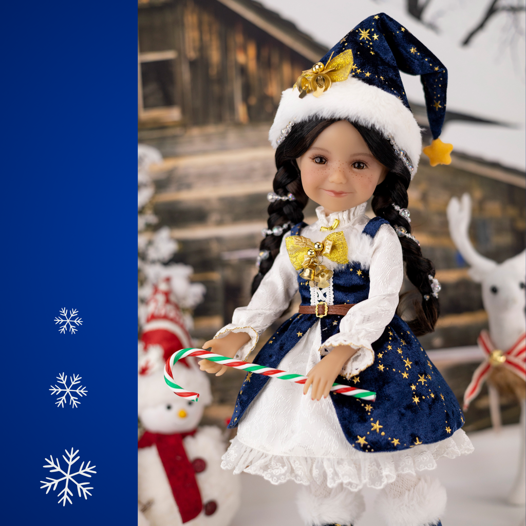 Ruby Red 2025 Holiday edition doll Carol, with festive blue and white outfit and accessories, surrounded by Christmas decorations.