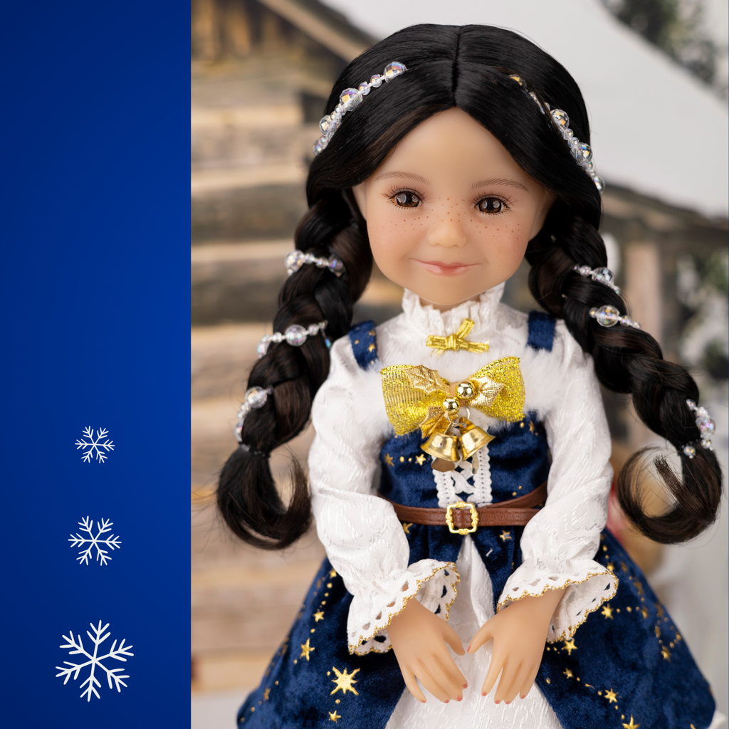 Ruby Red 2025 Holiday edition doll Carol, with festive blue and white outfit and accessories, surrounded by Christmas decorations.